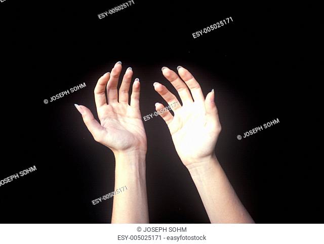 Special effects composite of two hands and black sky