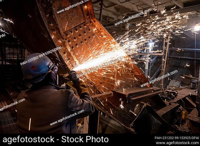 PRODUCTION - 01 December 2023, Mecklenburg-Western Pomerania, Stralsund: Workers replace a plate in the middle of the sailing ship ""Gorch Fock 1"" that was...