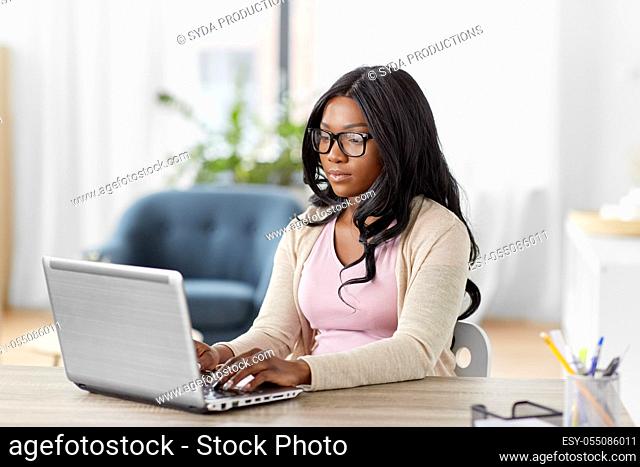 african woman with laptop working at home office