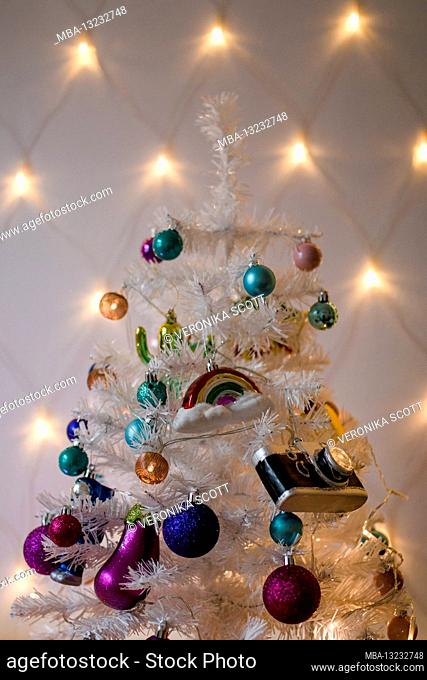 Kitschy plastic Christmas tree in white with colorful balls and pendants