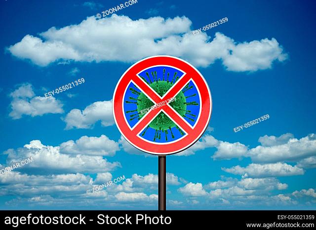 Prohibition sign with crossed out Coronavirus, Covid-19 molecule on the background of blue cloudy sky. Restriction of air communication between countries