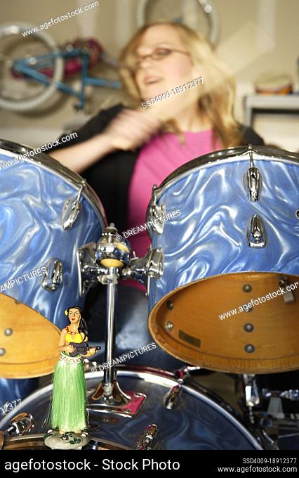Detail of hula girl on drum with Drummer in garage band composed of middle aged women, practicing in residential garage