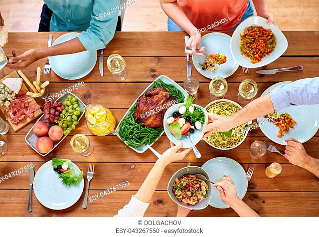 thanksgiving day, eating and leisure concept - group of people having dinner at table with food