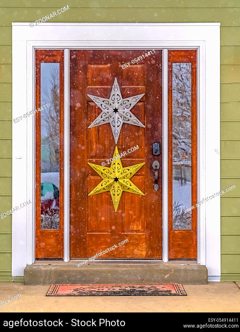 Glass paned wooden door with star decoration. Front door of a home in Daybreak, Utah decorated with silver and gold stars