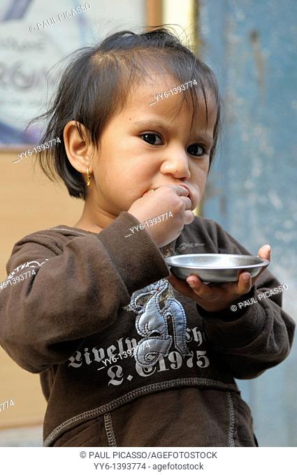 little nepalis girl eating , the nepalis , life in kathmandu , kathmandu street life , nepal