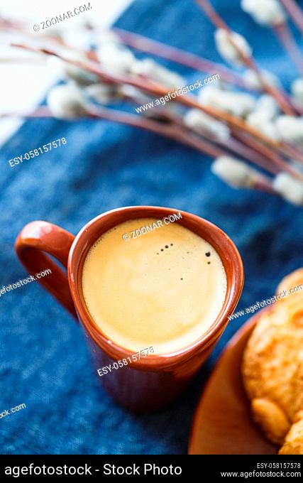 A cup of espresso on a table with cookies in a saucer