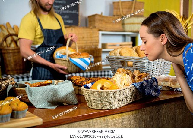 Woman smelling a breads at counter