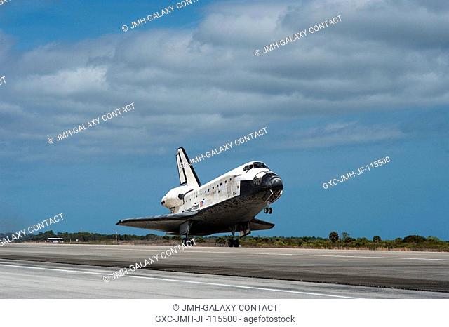 Space shuttle Discovery's main gear touches down on Runway 15 at the Shuttle Landing Facility at NASA's Kennedy Space Center in Florida