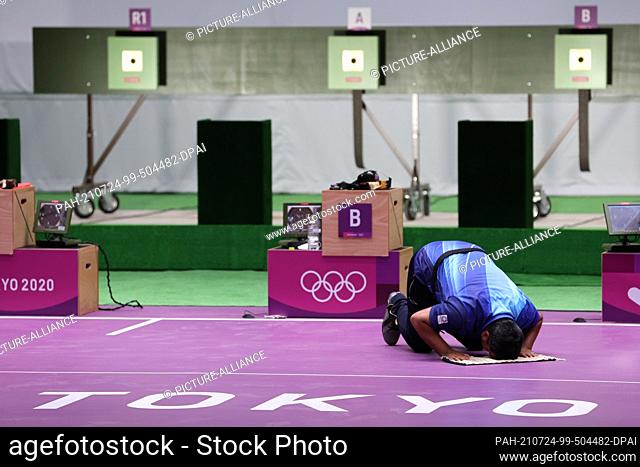 24 July 2021, Japan, Tokio: Shooting: Olympics, final, air pistol 10 m, men, in the Asaka Shooting Range. Javad Foroughi from Iran kneels on the ground