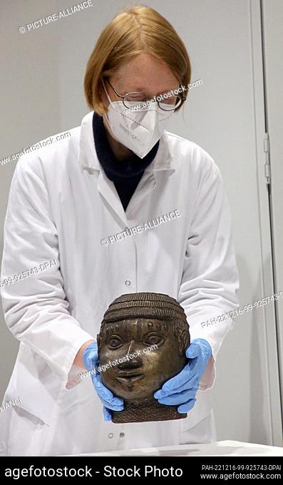 06 December 2022, Berlin: A museum employee packs one of the Benin bronzes assembled for return to Nigeria at the Ethnological Museum Dahlem