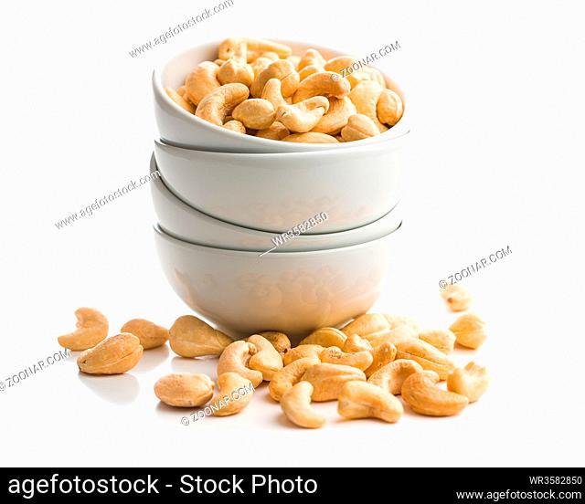 Roasted cashew nuts in bowl isolated on white background