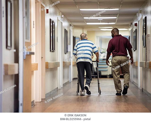 Nurse walking with patient using walker