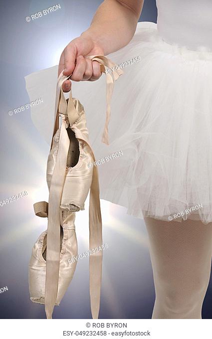 Professional woman ballerina holding her pointe shoes
