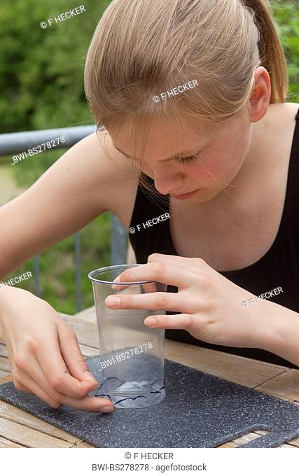 teenage girl tinkering a loupe, Germany