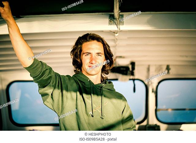 Portrait of teenage boy in fishing boat on coast of Maine, USA