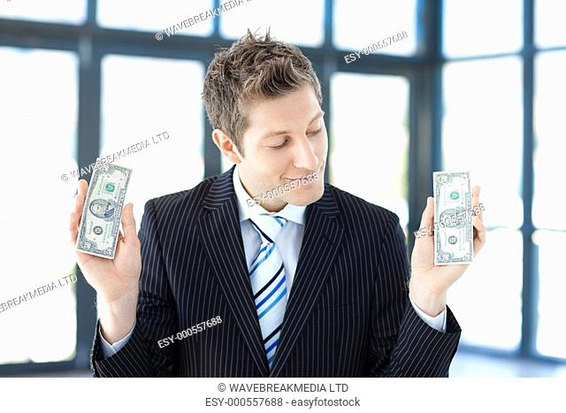 Smiling businessman holding money in office