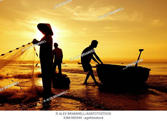 Silhouetted fishermen on Mui Ne Beach in Vietnam