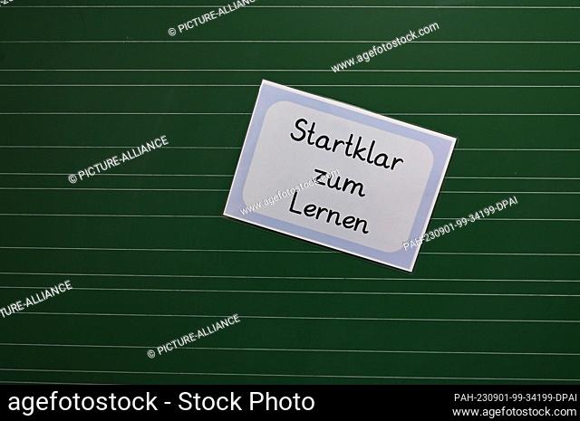 PRODUCTION - 29 August 2023, Hesse, Wiesbaden: A laminated sheet of paper with the inscription ""Startklar zum Lernen"" (Ready to learn) sticks to a blackboard...