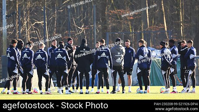 08 February 2023, Hamburg: Soccer: 2nd Bundesliga, Hamburger SV training. Coach Tim Walter stands in the players' circle before training and speaks to the team