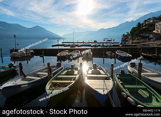 Harbor with Nautical Vessel and Sunlight and Mountain on Alpine lake Maggiore in Ascona, Switzerland