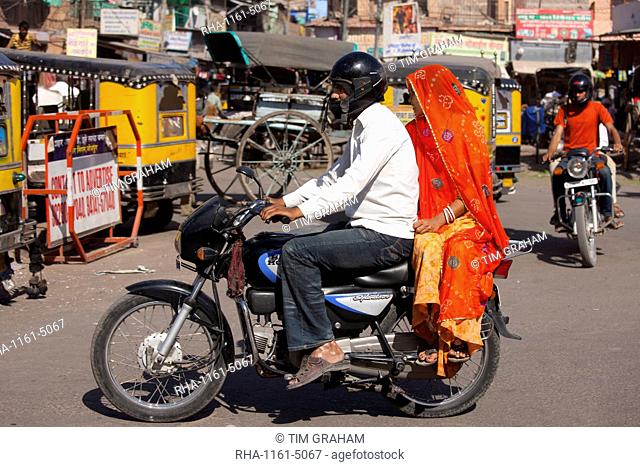 Indian couple riding motorcycle, street scene at Sardar Market at Girdikot, Jodhpur, Rajasthan, Northern India