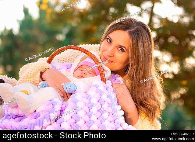 Mom hugs baby sleeping in basket