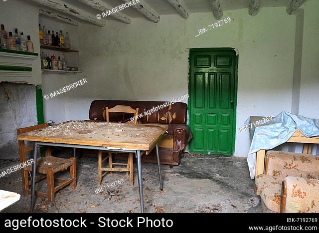 Room of an abandoned house with sofa, table and many bottles, Andalusia, Spain, Europe