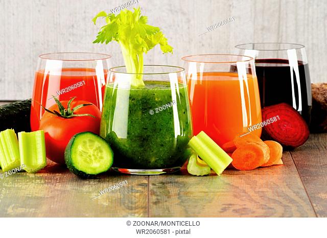 Glasses with fresh organic vegetable juices on wooden table. Detox diet