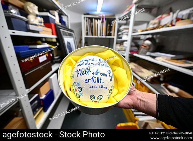 PRODUCTION - 18 December 2023, Baden-Württemberg, Stuttgart: An ostrich egg with the inscription ""Just open your eyes and you will see that the world is filled...