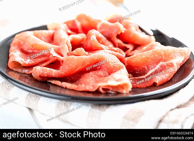 Sliced carpaccio. Raw beef meat on plate
