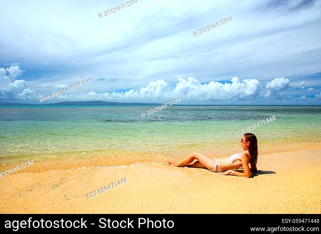 Young woman in bikini lying on the beach on Taveuni Island, Fiji. Taveuni is the third largest island in Fiji