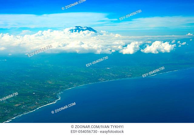Aerial view from aiprlane on Bali seashore and Agung volcano. Indonesia