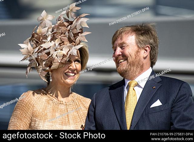 06 July 2021, Berlin: King Willem-Alexander of the Netherlands (r) and Queen Maxima laugh on the roof terrace of the Reichstag building of the German Bundestag