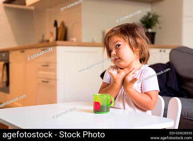 Toddler girl eating cookie and drink juice. Snack food for child. High quality 4k footage