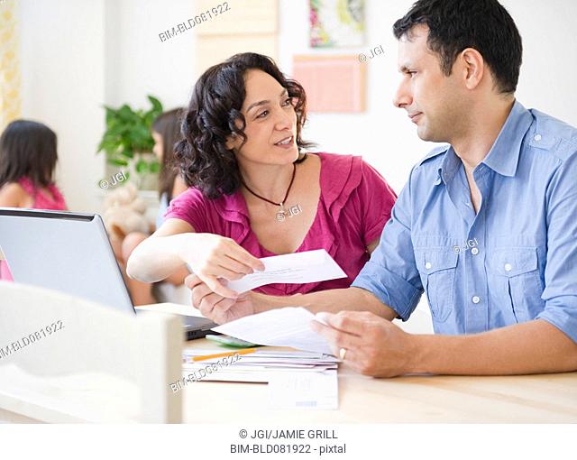 Husband and wife paying bills online with laptop
