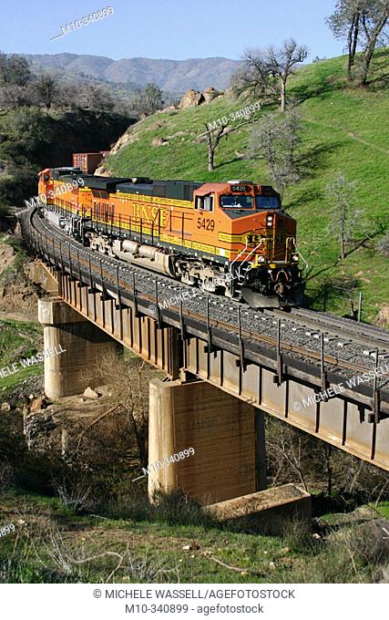 Burlington Northern Santa Fe Train crossing over an old bridge from the 1800's traveling from Bakersfield heading to Tehachapi in the early morning hours
