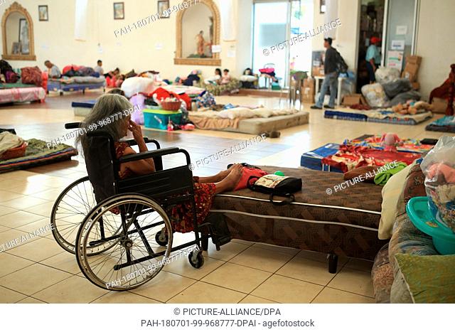 29 June 2018, Guatemala, Escuintla: A woman sitting in a wheelchair in the emergency shelter at the church 'Nuestra Senora de Guadalupe'