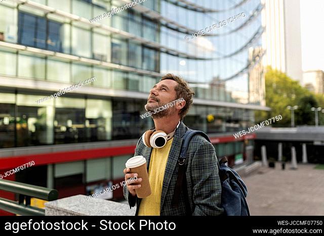 Man with disposable coffee cup in city