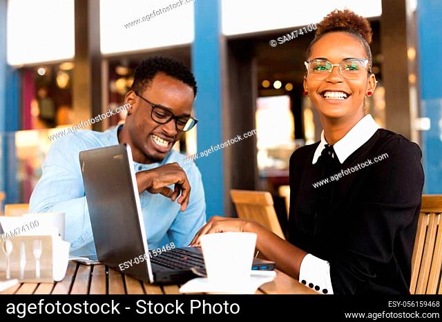Black African American coworkers doing digital teamwork arround a coffee cup