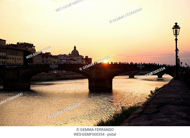 Italy, Florence, Tourists enjoying the sunset at Ponte Santa Trinita