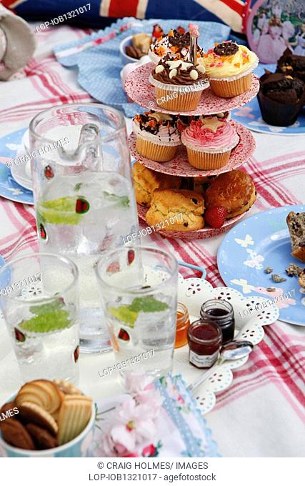 England, West Midlands, Edgbaston, A picnic table laid out with cakes and biscuits in the Botanical Gardens in Edgbaston, Birmingham
