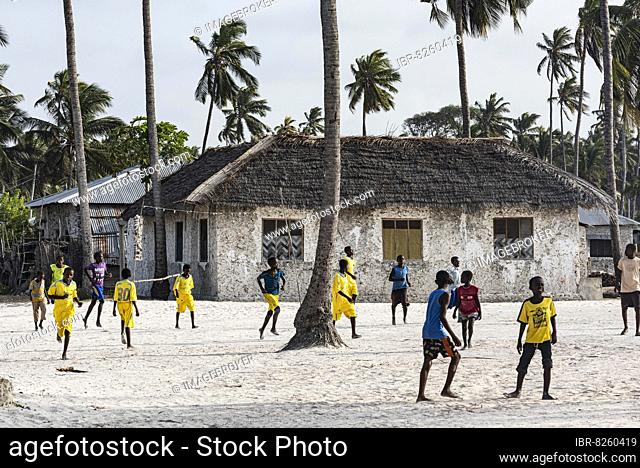 Jungen spielen Fußball im Dorf Jambiani, gelbe Trikots, Unguja, Ostküste, Sansibar, Tansania