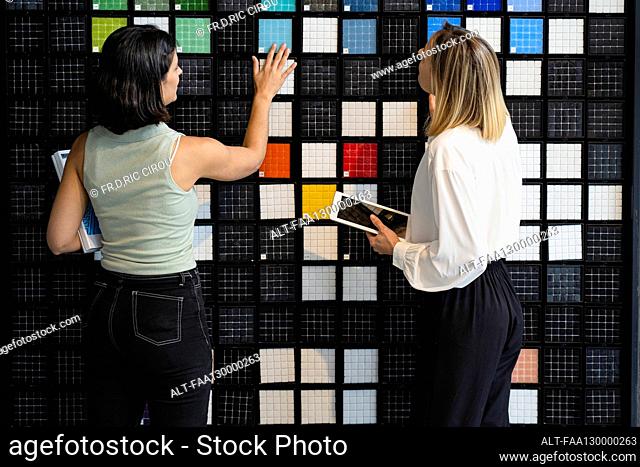 Two female home decorators choosing patterns in their studio