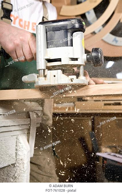 Detail of a carpenter using a sanding machine