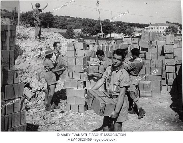 Scouts landing food at Argostolion, Kefalonia, Greece. Four earthquakes hit the island in August 1953, destroying many buildings; the scouts helped with...
