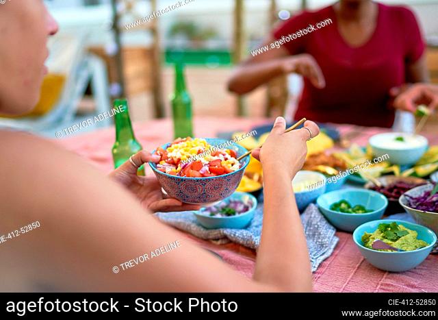 Young woman eating lunch at patio table