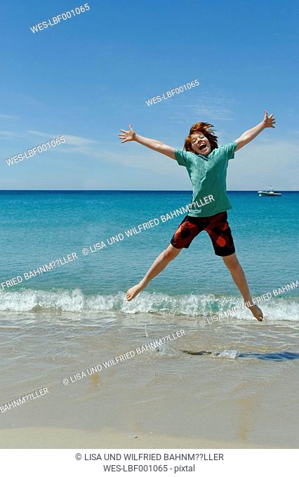 France, Corsica, Favone, boy having fun at a beach