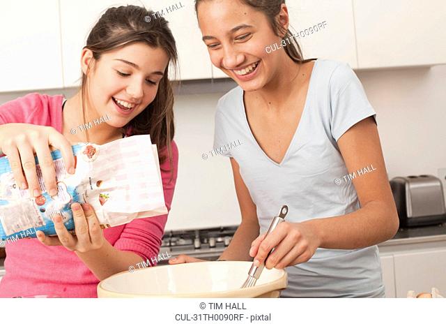 teenage girls preparing food in kitchen
