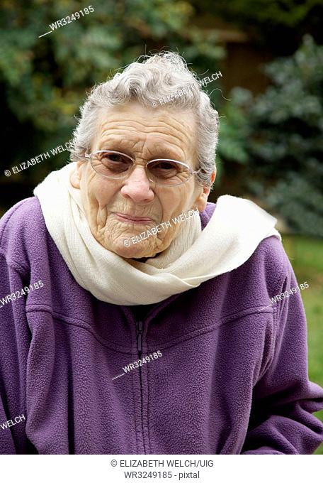 Elderly woman feeling very cold due to freezing temperatures