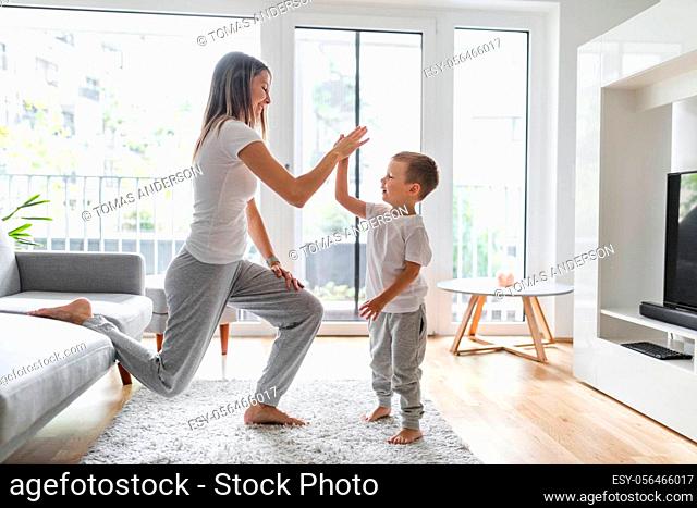 Mom with her young son working out in the living room